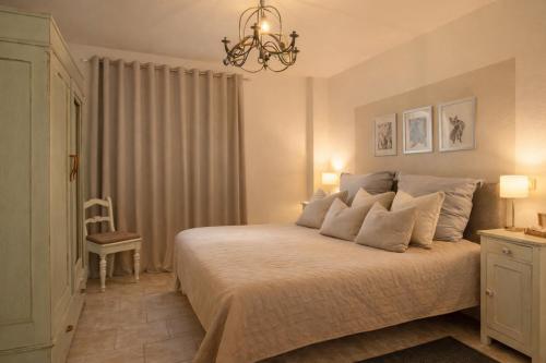 a bedroom with a large bed with a chandelier at Wildblick Appartment Hof Grindelborn in Mürlenbach