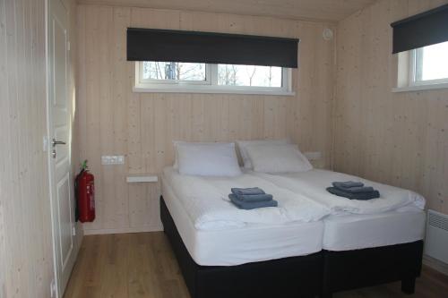 a bedroom with a bed with two towels on it at Svala Guesthouses in Selfoss