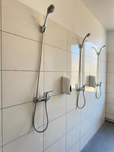 a bathroom with a shower with a shower head at Smilšu ielas Hostelis in Valmiera