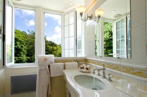 a bathroom with a sink and a mirror at Le Manoir Hôtel Le Touquet Paris Plage in Le Touquet-Paris-Plage