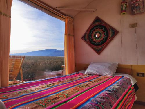 a bed in a room with a large window at Los Uros in Puno