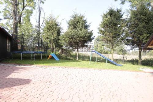 un parque con 2 columpios y un parque infantil en U Majerczyka II, en Zakopane