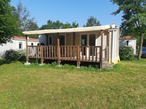 a tiny house with a porch and a deck at Camping Onlycamp Les Peupliers du Lac in Chindrieux