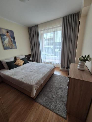 a bedroom with a large bed and a large window at Marina Park OLIWIA in Sveti Vlas