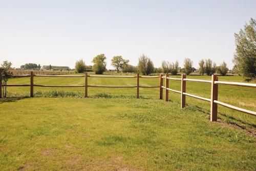 a fence in the middle of a field at Huisje Meersen in Maldegem