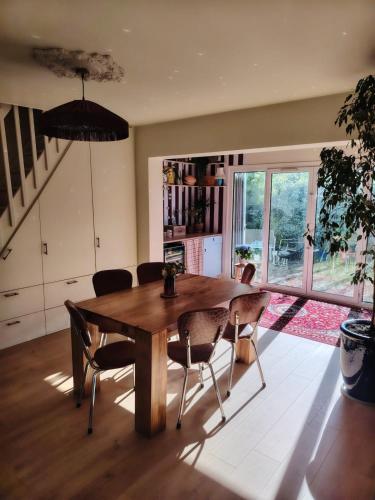 a dining room with a wooden table and chairs at Maison La Séréna in Arès
