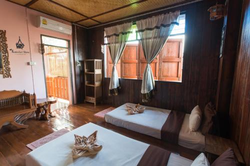 a bedroom with two beds and a window at Kanecha's Home Lampang in Lampang