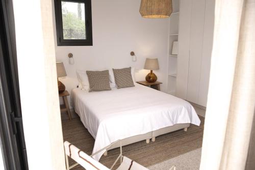 a bedroom with a white bed and a window at Stylish Villa, Rural Setting, Infinity Pool in Pano Akourdalia