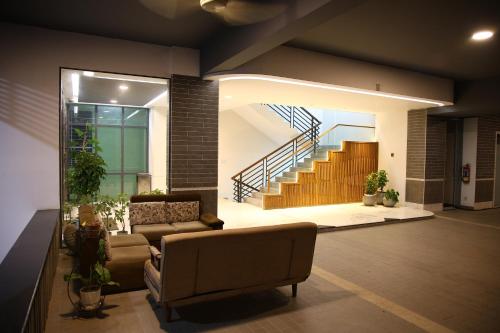 a living room with a couch and a staircase at Pearl Serenity in Sholāshahar