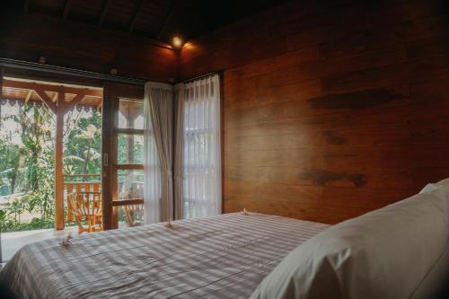 a bedroom with a bed in front of a window at ChannaS villas in Payangan