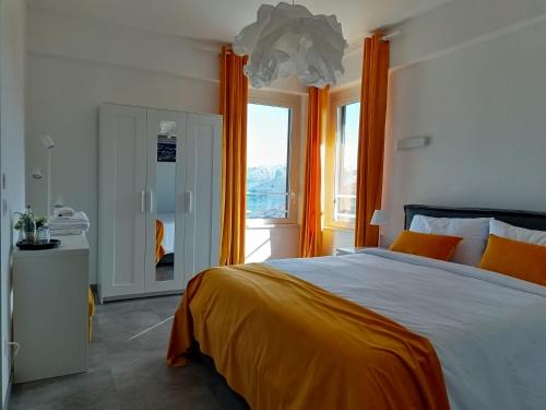 a bedroom with a bed with orange curtains and a window at vitalArmonie Retreat in Marzio