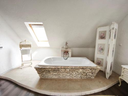 a large bath tub in a room with a window at Lesence Major in Lesencetomaj