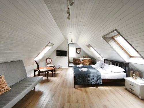 a bedroom with a bed and a couch in a attic at Lesence Major in Lesencetomaj
