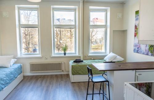 a room with windows and a bed and a desk at Grand Jugend Studio in Kallio in Helsinki