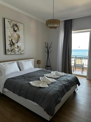 a bedroom with a large bed with two hats on it at KAMVISSIS HOTEL in Tyros
