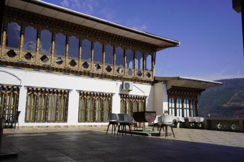a building with chairs and tables on a patio at Kingaling Hotel in Punākha