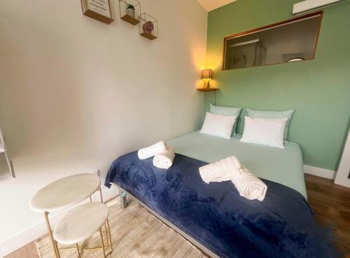 a bedroom with a bed and a table and a mirror at Petit cocon avec terrasse privée à Saint Barthélémy in Saint-Barthélemy-dʼAnjou
