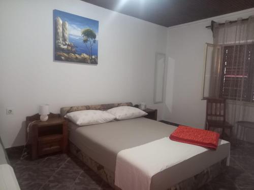 a bedroom with two beds and a painting on the wall at Kuca za odmor Maestral in Privlaka