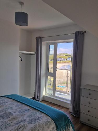 a bedroom with a window with a view of the beach at Beachview Rental in Clare Island