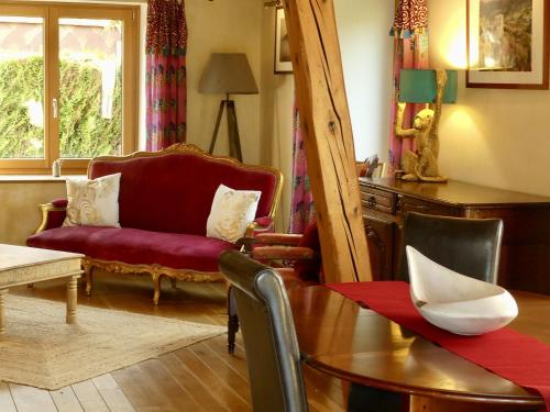 a living room with a red couch and a table at Basel Landskron Haus in Leymen
