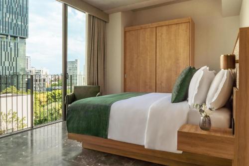 a bedroom with a large bed and a large window at NH Guadalajara Studios in Guadalajara