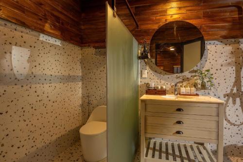 a bathroom with a toilet and a sink and a mirror at Maia House Homestay in Sóc Sơn