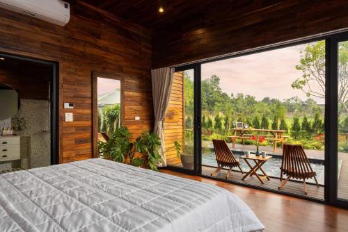 a bedroom with a bed and a large window at Maia House Homestay in Sóc Sơn