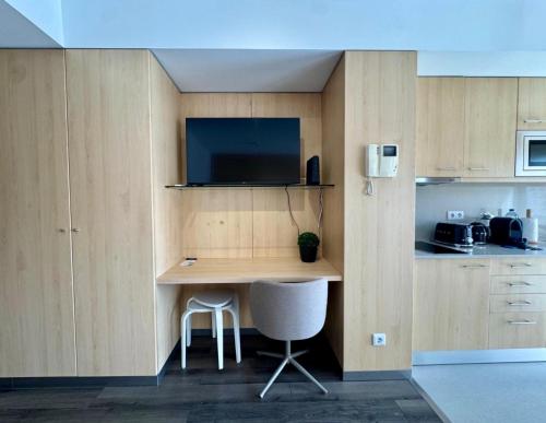 a kitchen with a desk with a tv on the wall at Antas Balcony Studio by LuxiStay in Porto
