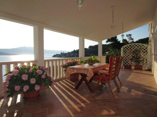 a porch with a table and chairs and flowers at Vila Tea in Korčula