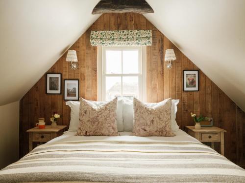 a bedroom with a large bed with a window at The Black Horse in Amberley