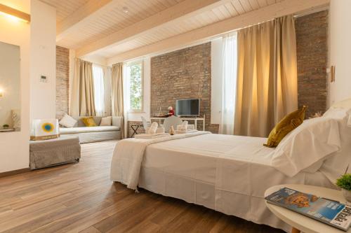a bedroom with a large white bed and a living room at Club del Sole Vigna sul Mar Family Collection in Lido di Pomposa
