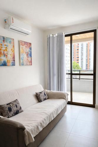 ein Wohnzimmer mit Sofa und großem Fenster in der Unterkunft Std Design Mar in Maceió