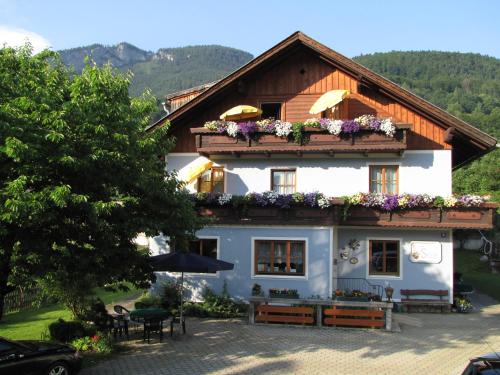 a house with flowers on the top of it at Pension Sydler in Bad Goisern