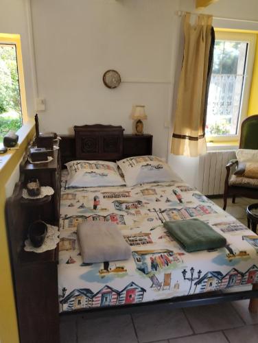 a bedroom with a bed with a quilt on it at Ty Kozh De L'aber in Crozon