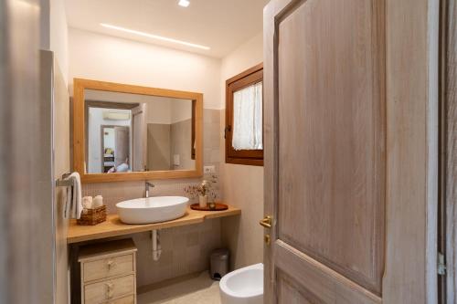 a bathroom with a sink and a mirror at Porto Cervo-Villa La Gjanda in Abbiadori