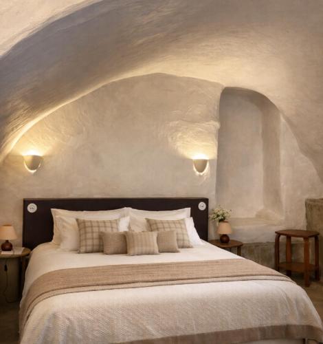 a bedroom with a large white bed with an archway at L'Hostal de Piaghja in Calenzana