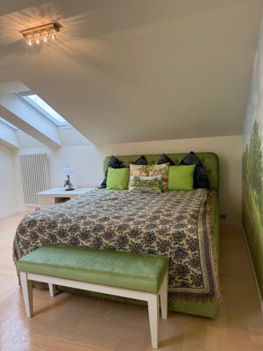 a bedroom with a bed with a green comforter at Lily Rose villa in Karlovy Vary