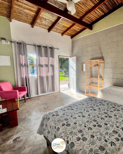 a bedroom with a bed and a chair and a window at Villa Dona Jaca - Cabana 2 in Socorro