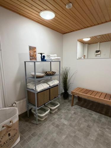 a room with a shelf with towels and a bench at Meri-Karina in Turku
