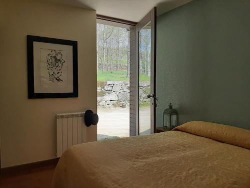a bedroom with a bed and a sliding glass door at Casa das Rosas in Cimbres