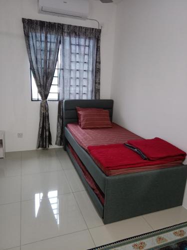 a bed sitting in a room with a window at D'Suriah Homestay in Tanjung Karang