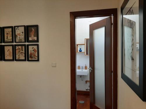 a hallway with a door and pictures on a wall at Casa das Rosas in Cimbres