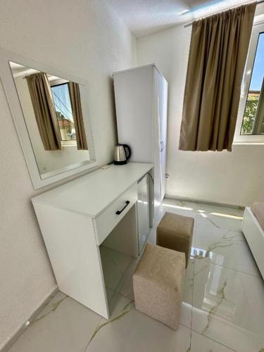 a white bathroom with a counter and a mirror at Dilans apartments by the sea in Bar