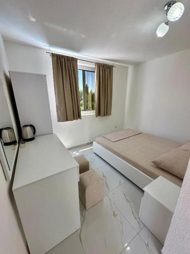 a white room with a bed and a window at Dilans apartments by the sea in Bar