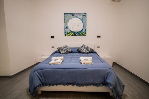 a bedroom with a blue bed with towels on it at Casa Peppina in Gubbio