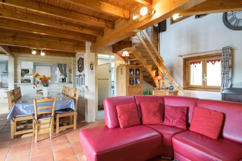 a living room with a red couch and a table at Les Clarines in Mouthe