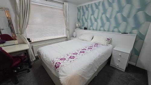 a bedroom with a bed and a desk and a window at Double room in Reading in Earley