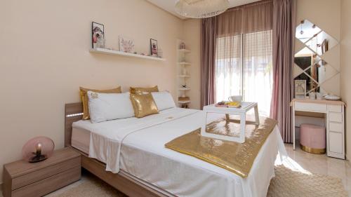 a bedroom with a large bed with a table on it at Cosy appartement in Bouznika