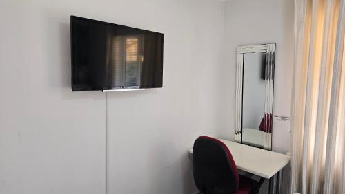 a room with a desk and a television on a wall at Double room in Reading in Earley