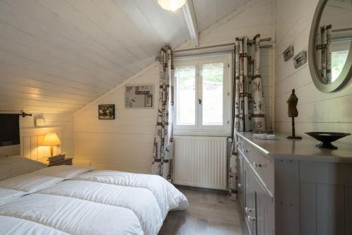 two beds in a attic bedroom with a window at Les Clarines in Mouthe